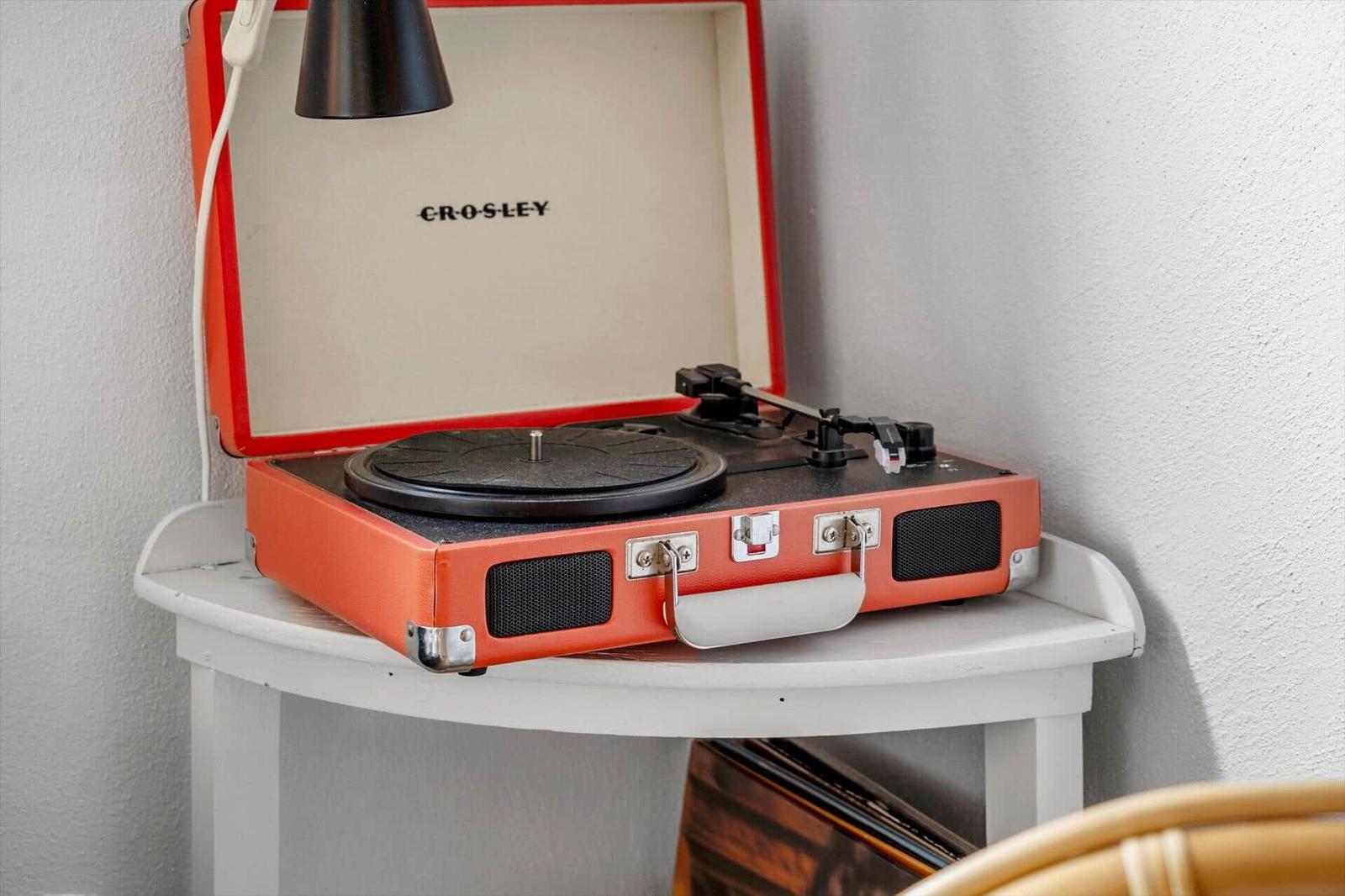 An orange record player on a white table.