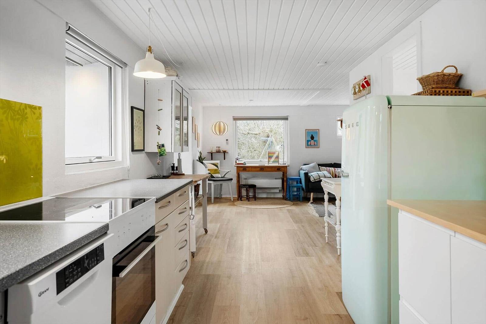 Kitchen with light wood floor and mint green refrigerator