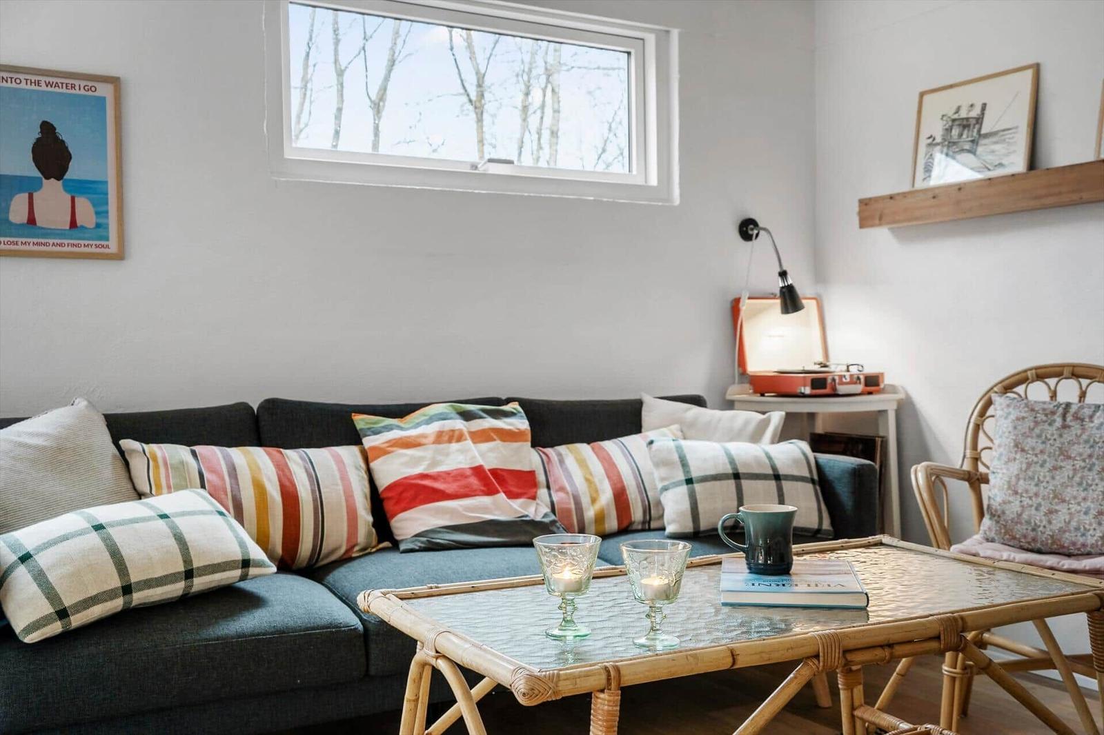 Living room with sofa, coffee table, and window. On the table are two glasses and a mug.