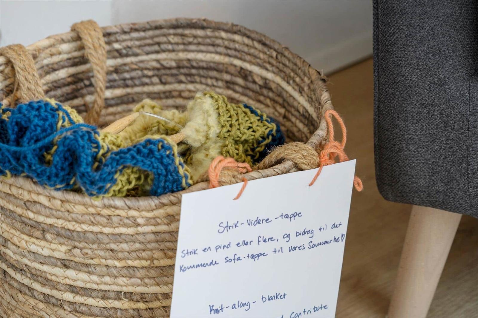 Basket with knitting supplies and note for sofa blanket