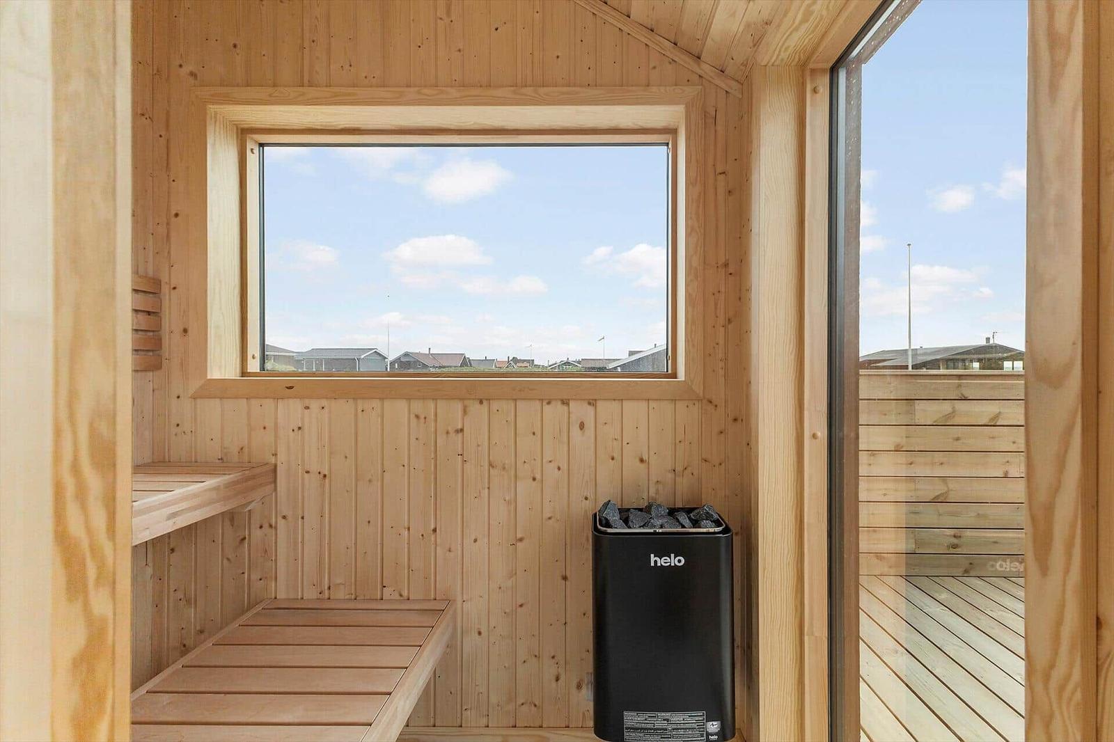Holzsauna mit Sitzbänken und Blick auf den Außenbereich.