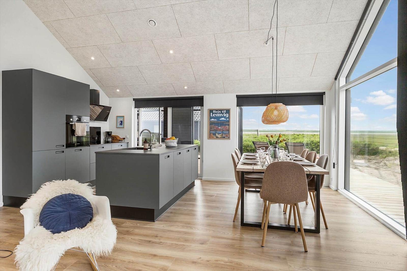 Moderne Küche mit Essbereich und großem Fensterblick auf Landschaft.