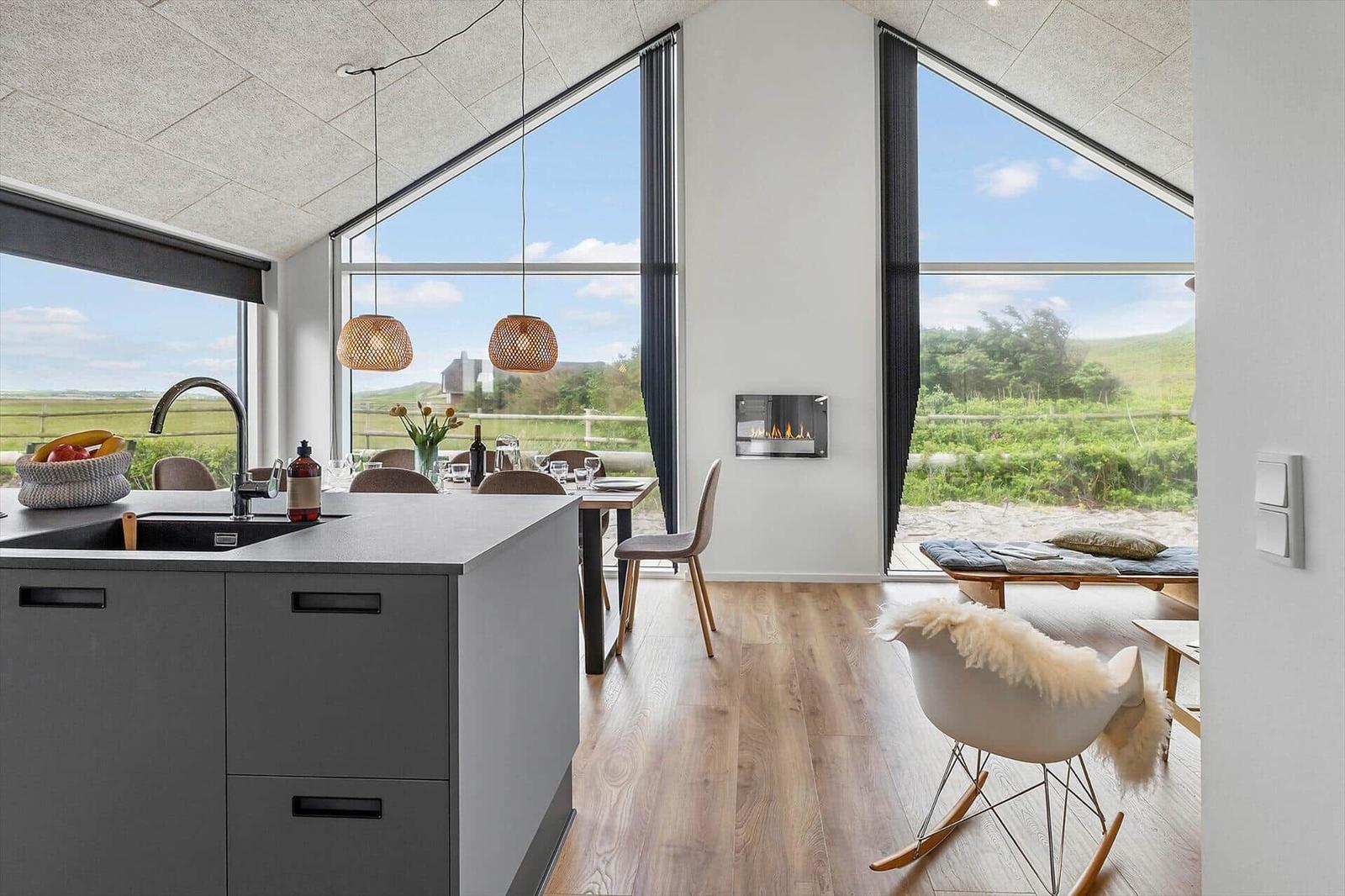 Küche mit Essbereich und großem Fensterblick auf Landschaft.