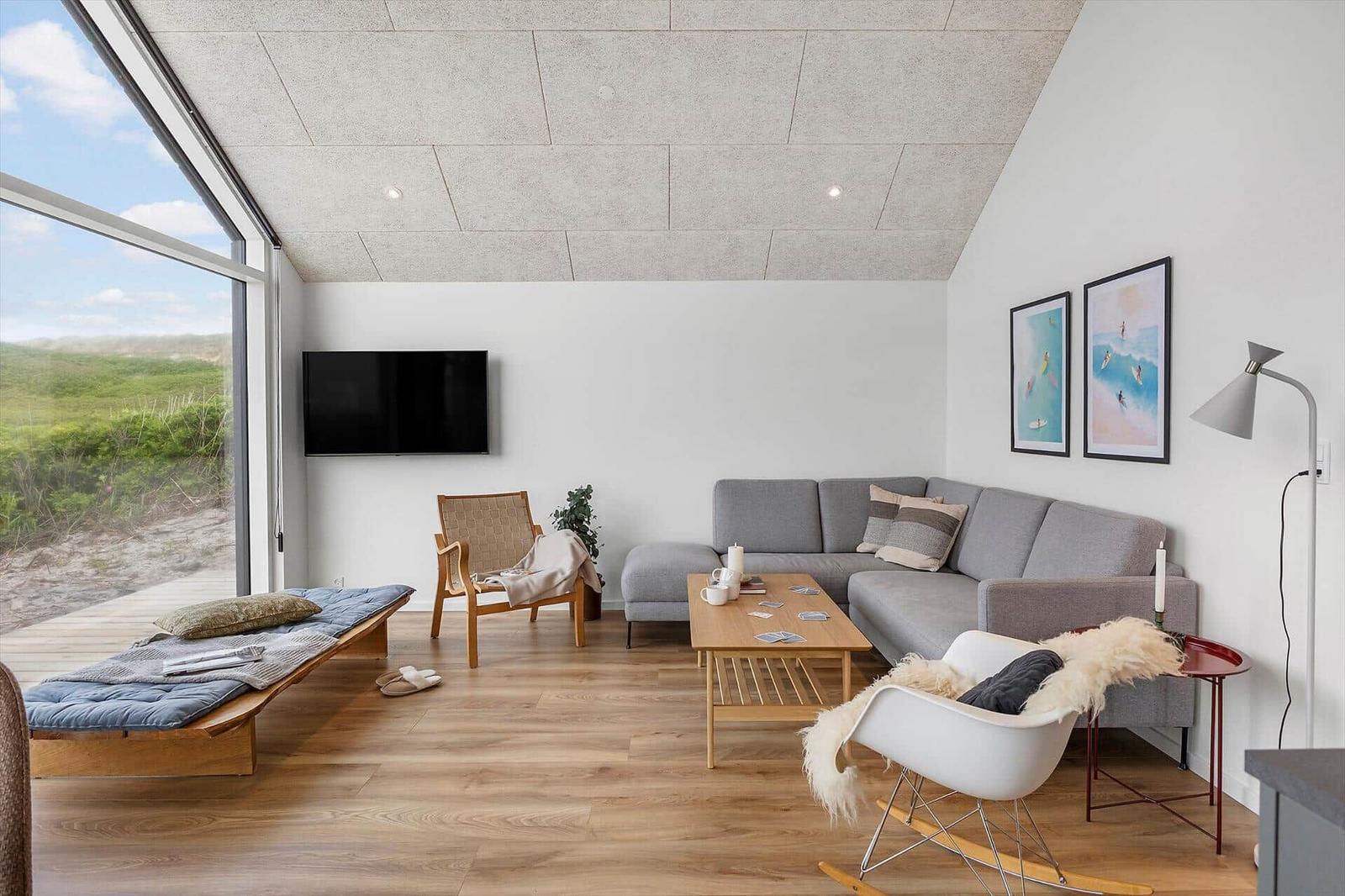 Wohnzimmer mit Sofa, Couchtisch und großem Fenster zur Aussicht