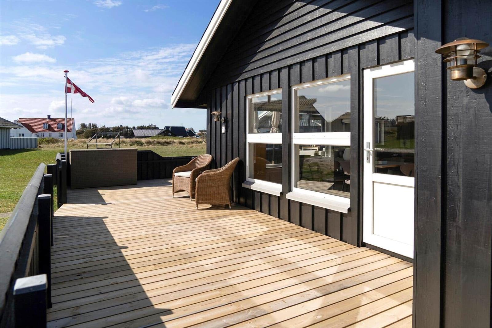 Terrasse mit zwei Stühlen, Flagge und Blick auf die Landschaft.