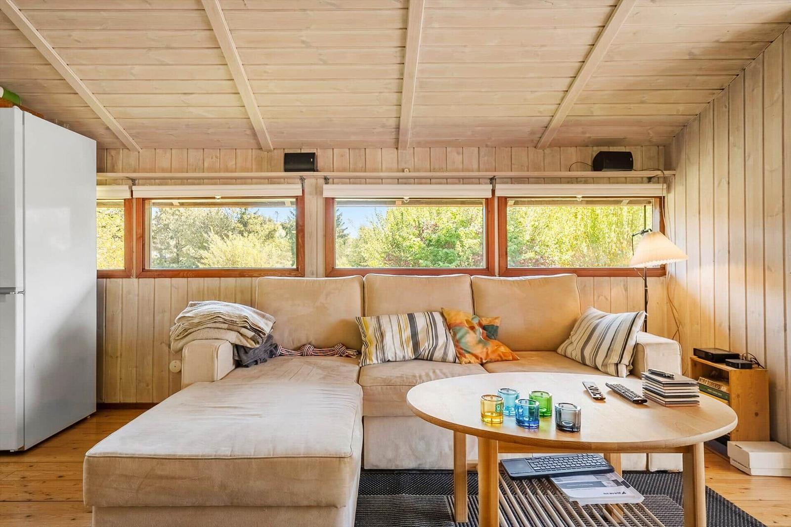 Living room with sofa, round table, and windows to the garden.