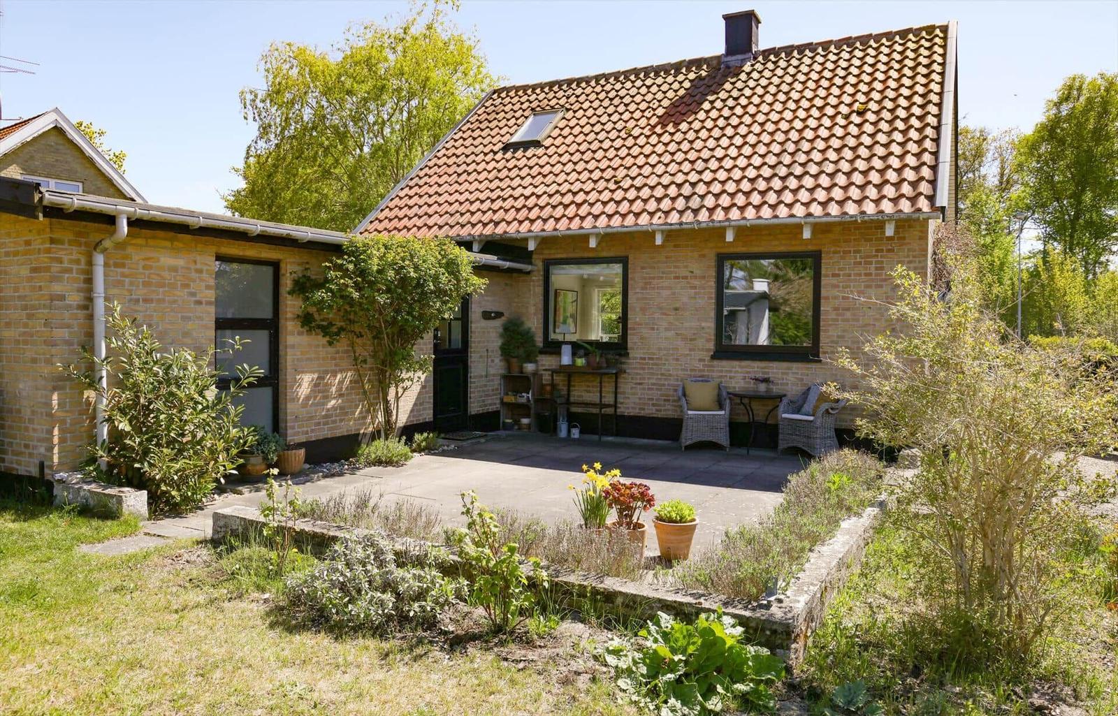 House with terrace, garden, and tiled roof. View of interior and outdoor area.