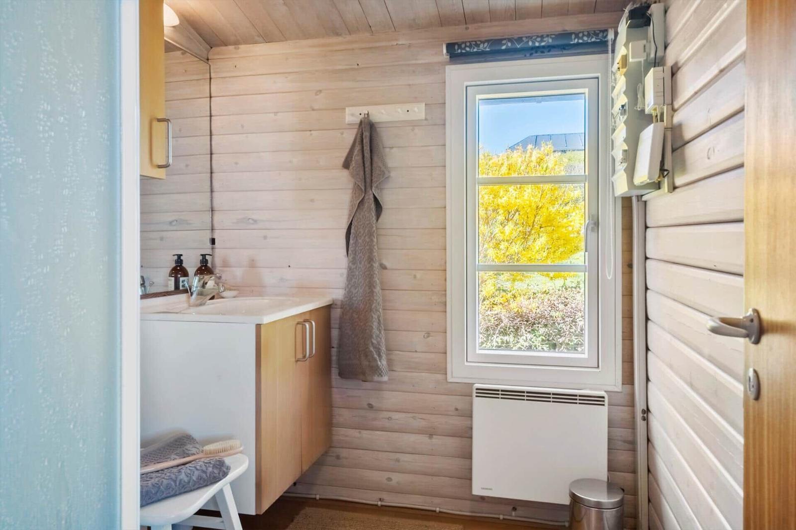 Badezimmer mit Holzwand, Fenster und Waschbecken