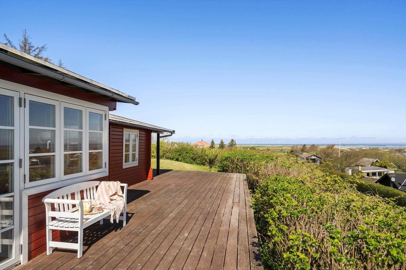 Terrasse mit weißem Stuhl und Blick auf die Landschaft.