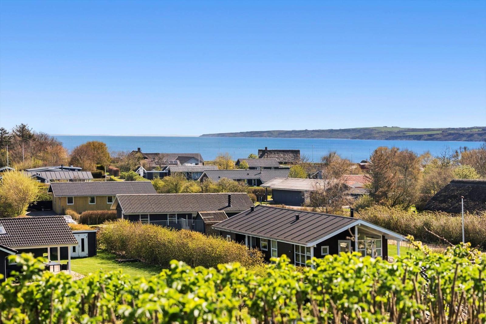 Meerblick von einem Ferienhaus mit Garten und umliegenden Häusern.