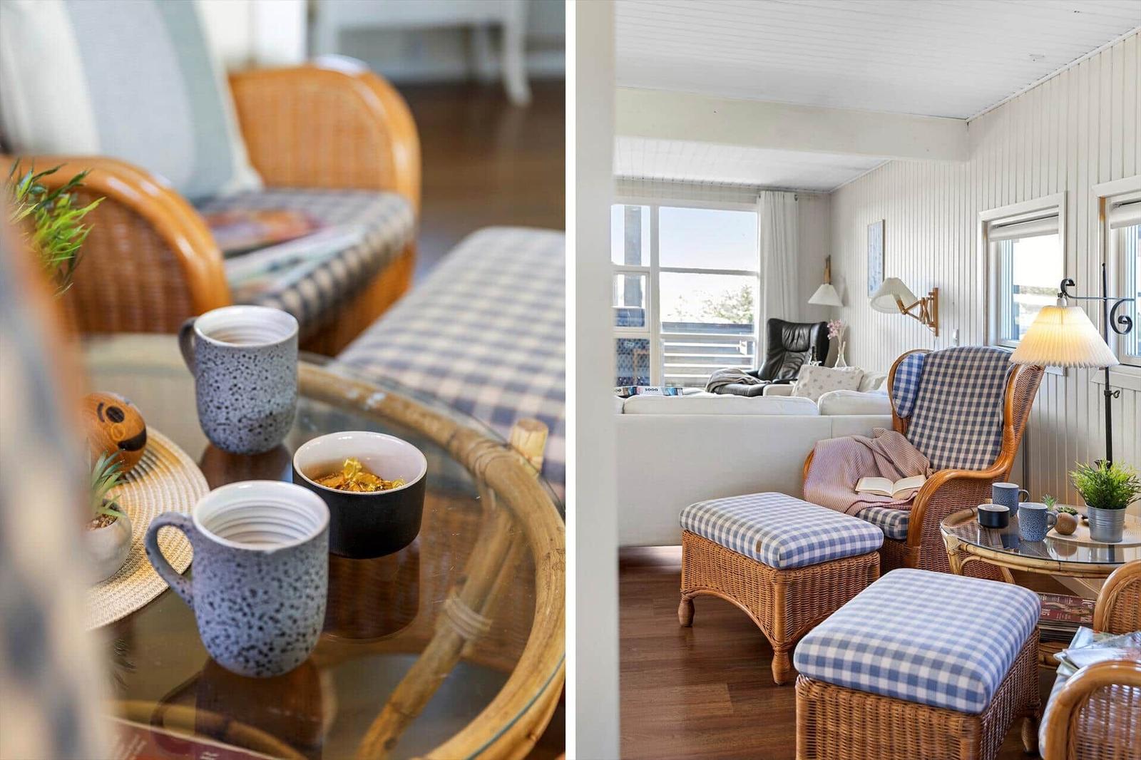 Wohnzimmer mit Wickerstühlen, Glas-Tisch und blau-weiß karierten Sitzkissen.
