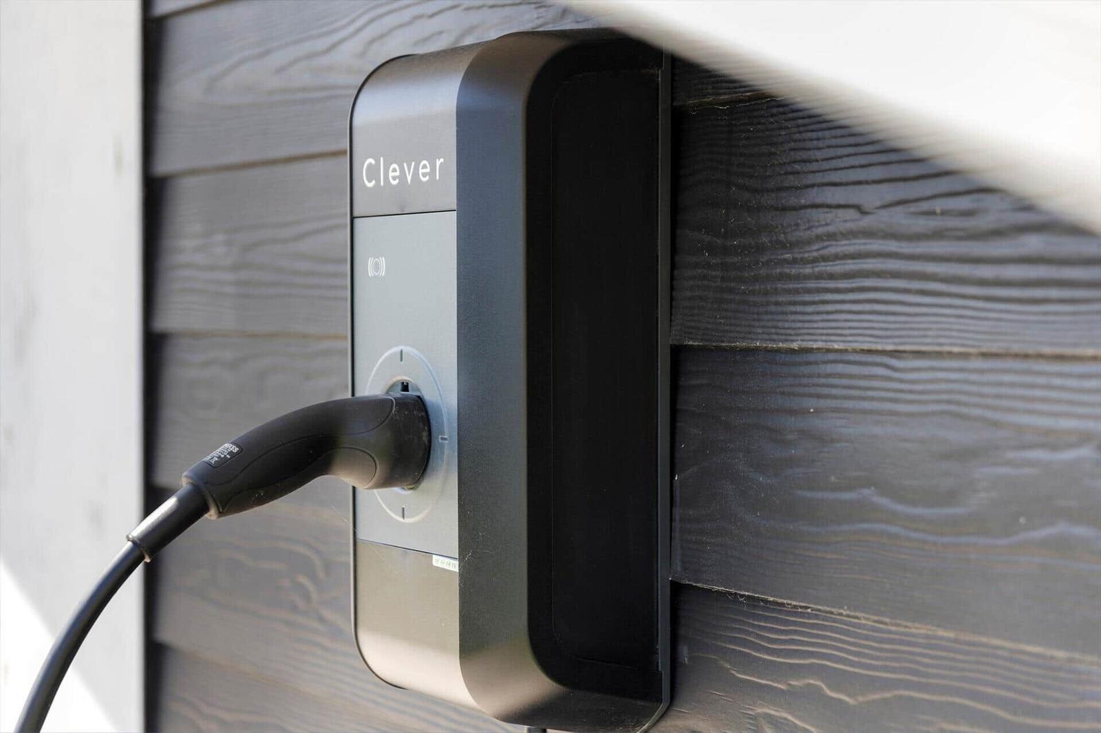 Ladestation Clever an einer Holzwand montiert, Kabel eingesteckt.