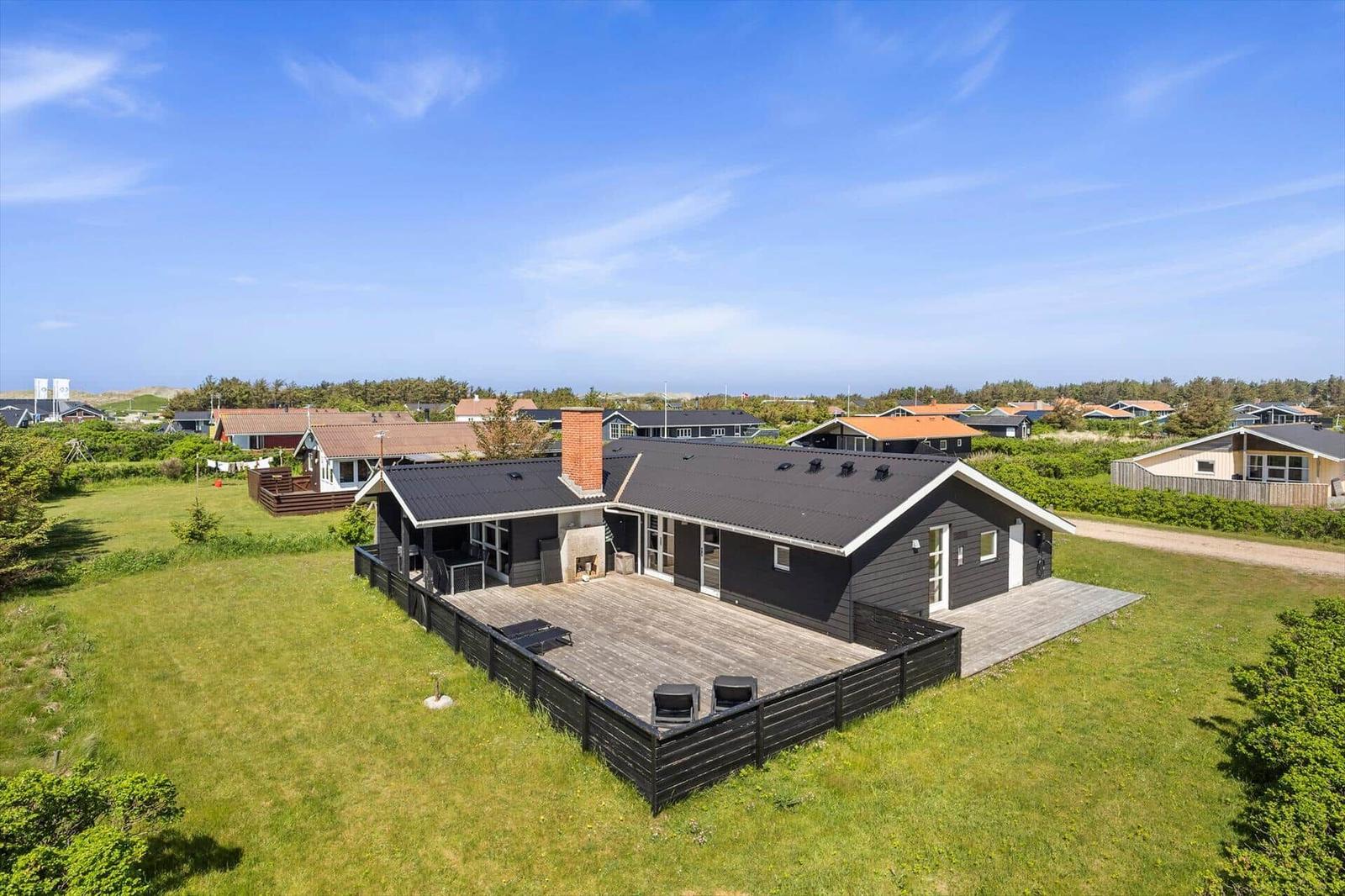 Moderne Villa mit Holzterrasse und Grillplatz in grüner Umgebung