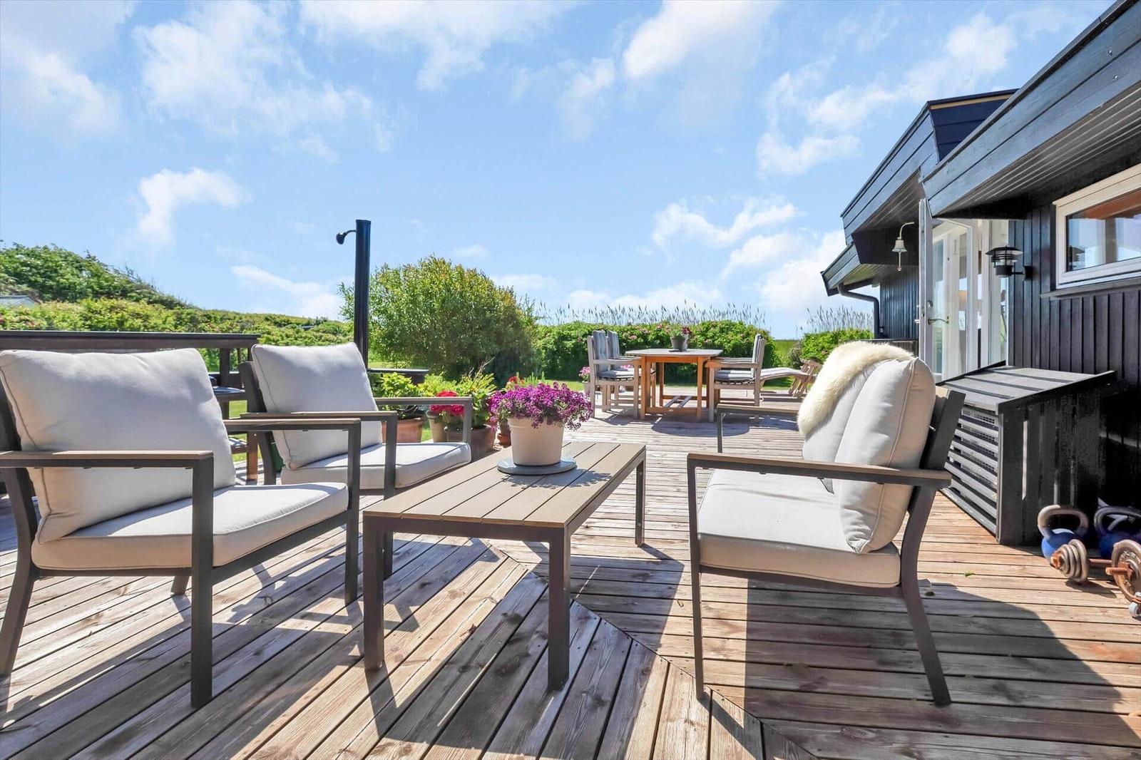 Terrasse mit Sitzgelegenheiten und Blick auf grüne Landschaft.