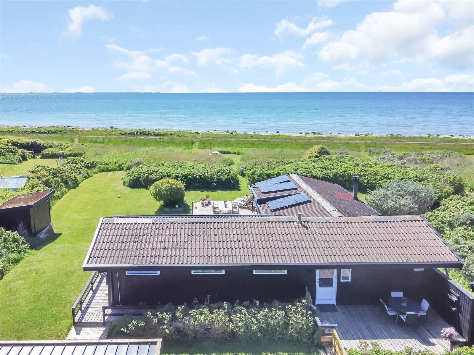 Haus mit Terrasse und Garten, Blick auf das Meer und grüne Wiesen.