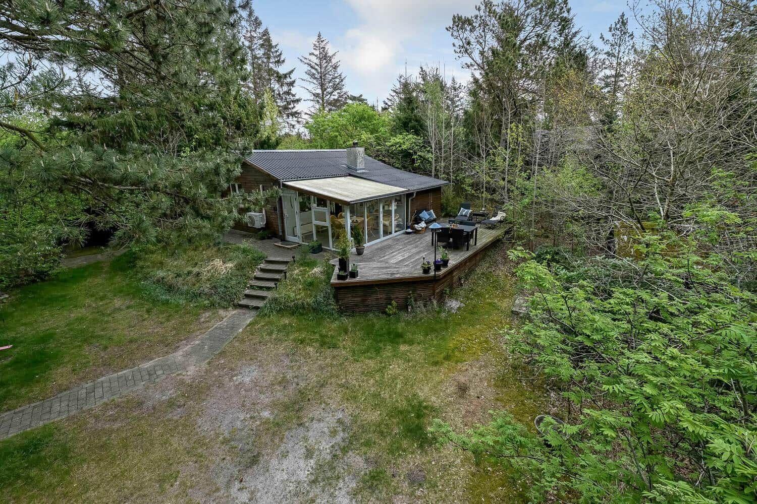 Haus mit Terrasse im Wald, mit Garten und Grillplatz.