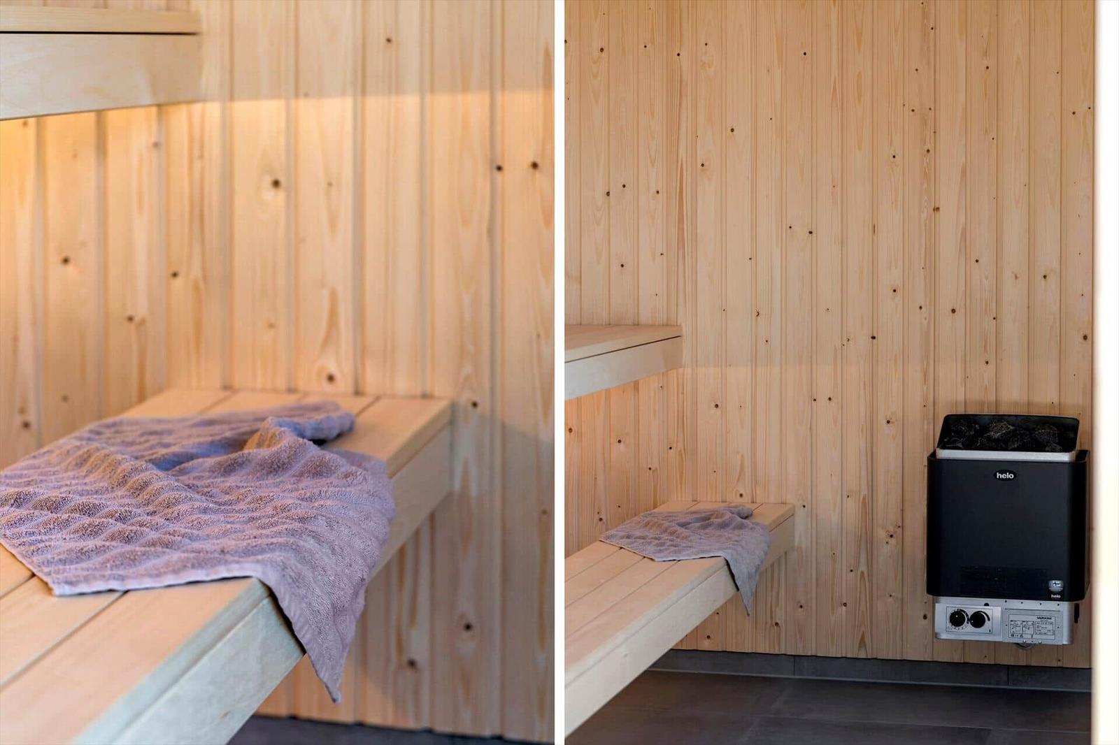 Sauna mit Holzwänden, Sitzbänken und Heizung. Handtuch liegt auf den Bänken.