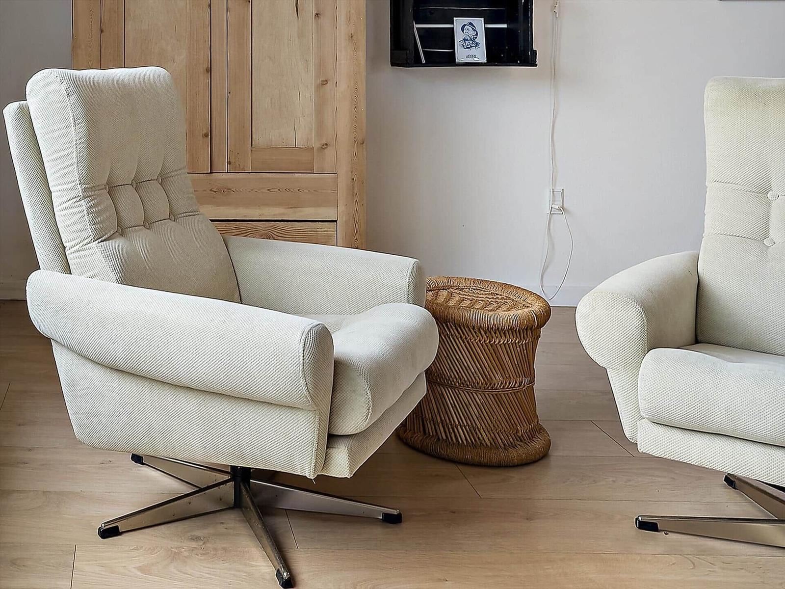 Two cream-colored chairs with metal base and round rattan table