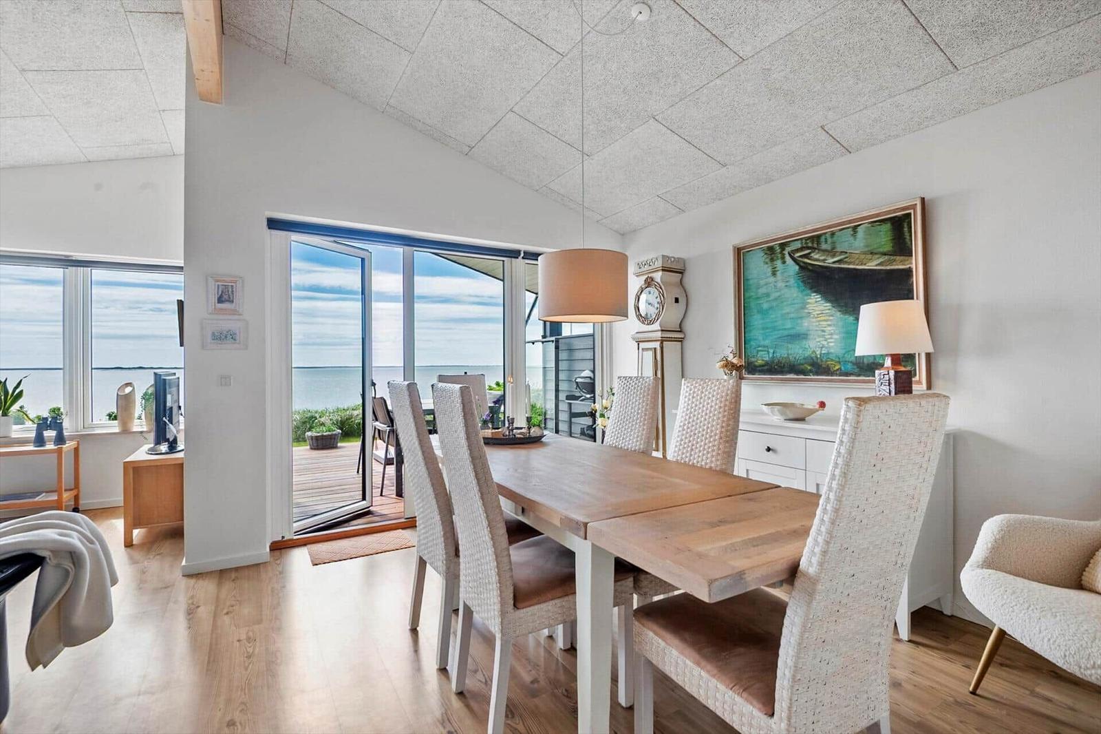 Essbereich mit Tisch und Stühlen, Blick auf die Terrasse und das Meer.