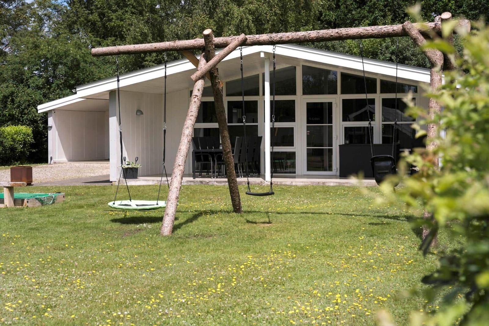 House with garden, swing, and outdoor table.