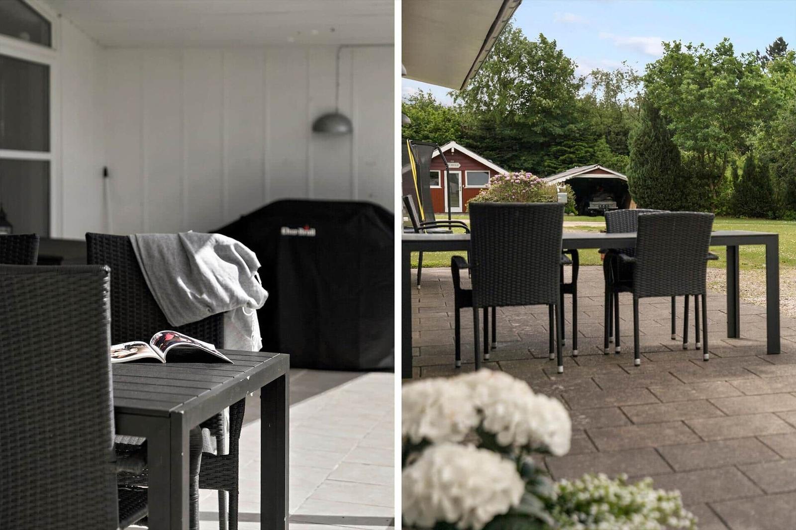 Terrace with table and chairs, grill, and view of garden with house.
