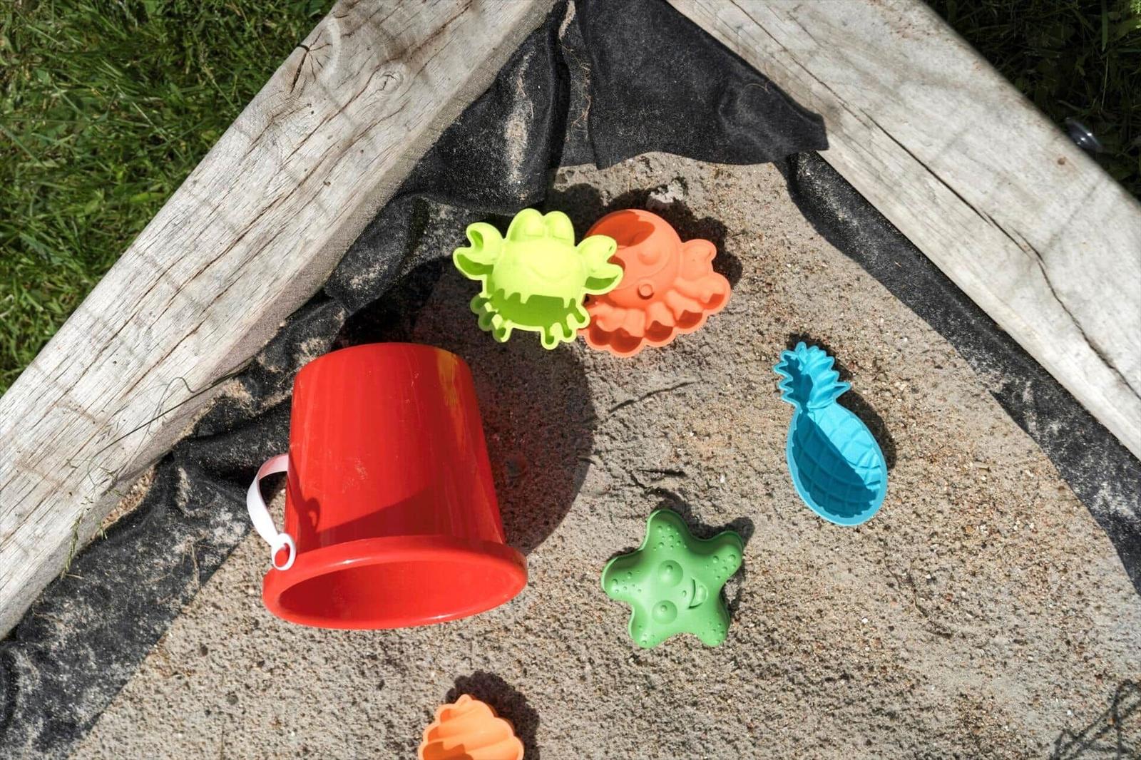 Childrens toys in sandbox with bucket and molds