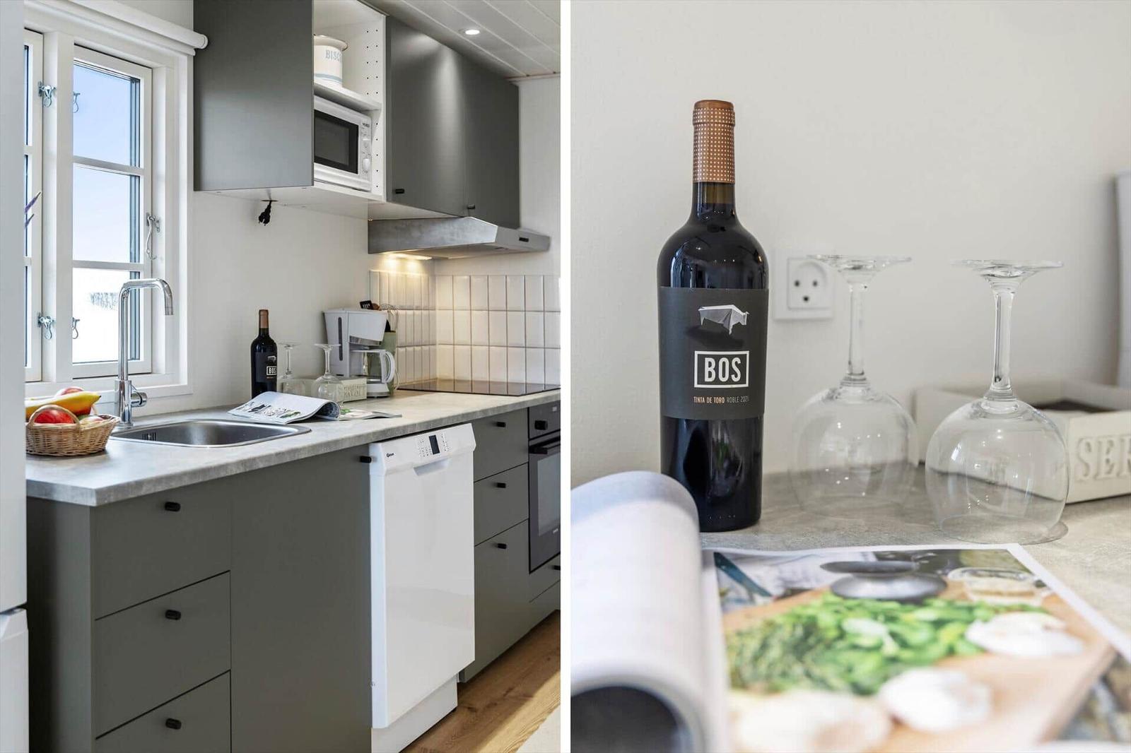 Küche mit Fenster, Spüle und Geschirrspüler. Flasche Wein und Gläser auf Arbeitsfläche.