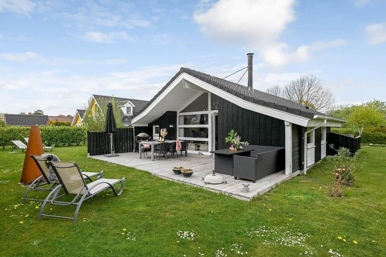 Moderne Villa mit Terrasse, Garten und Außensitzgelegenheiten.