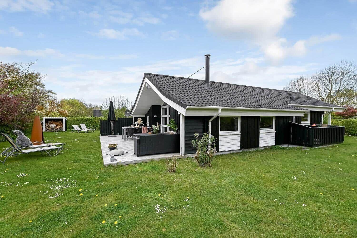 Moderne Villa mit Terrasse, Garten und Außensitzgelegenheiten.
