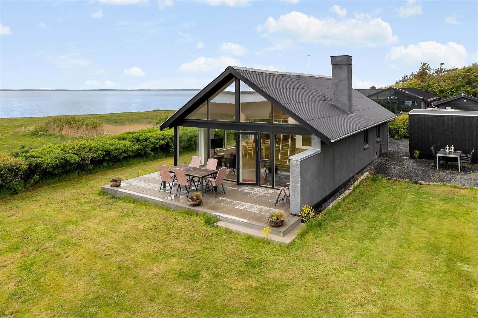 Modern villa with terrace and water view. Garden and barbecue area.