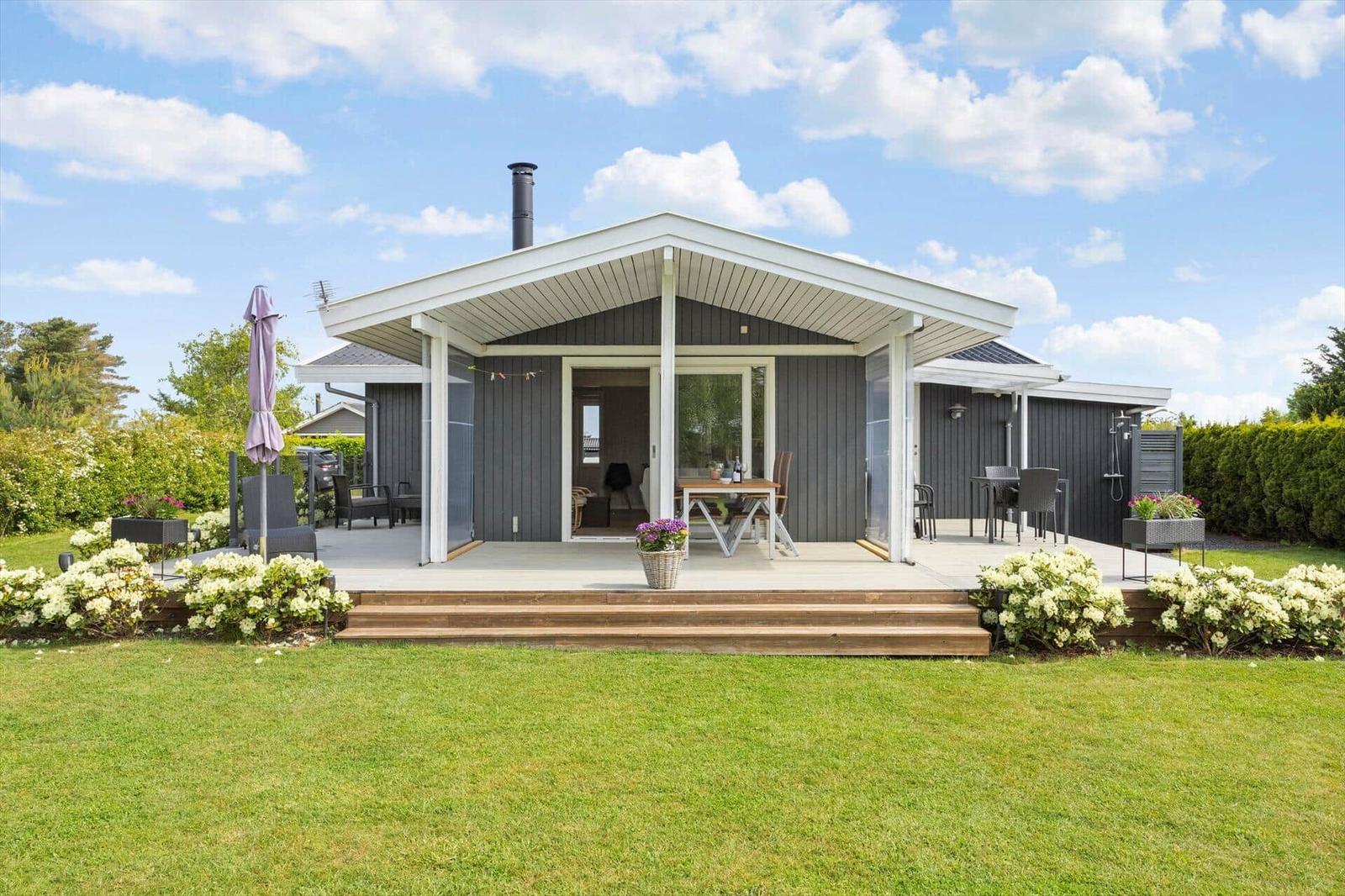 Modern villa with terrace, garden, and seating areas outdoors.