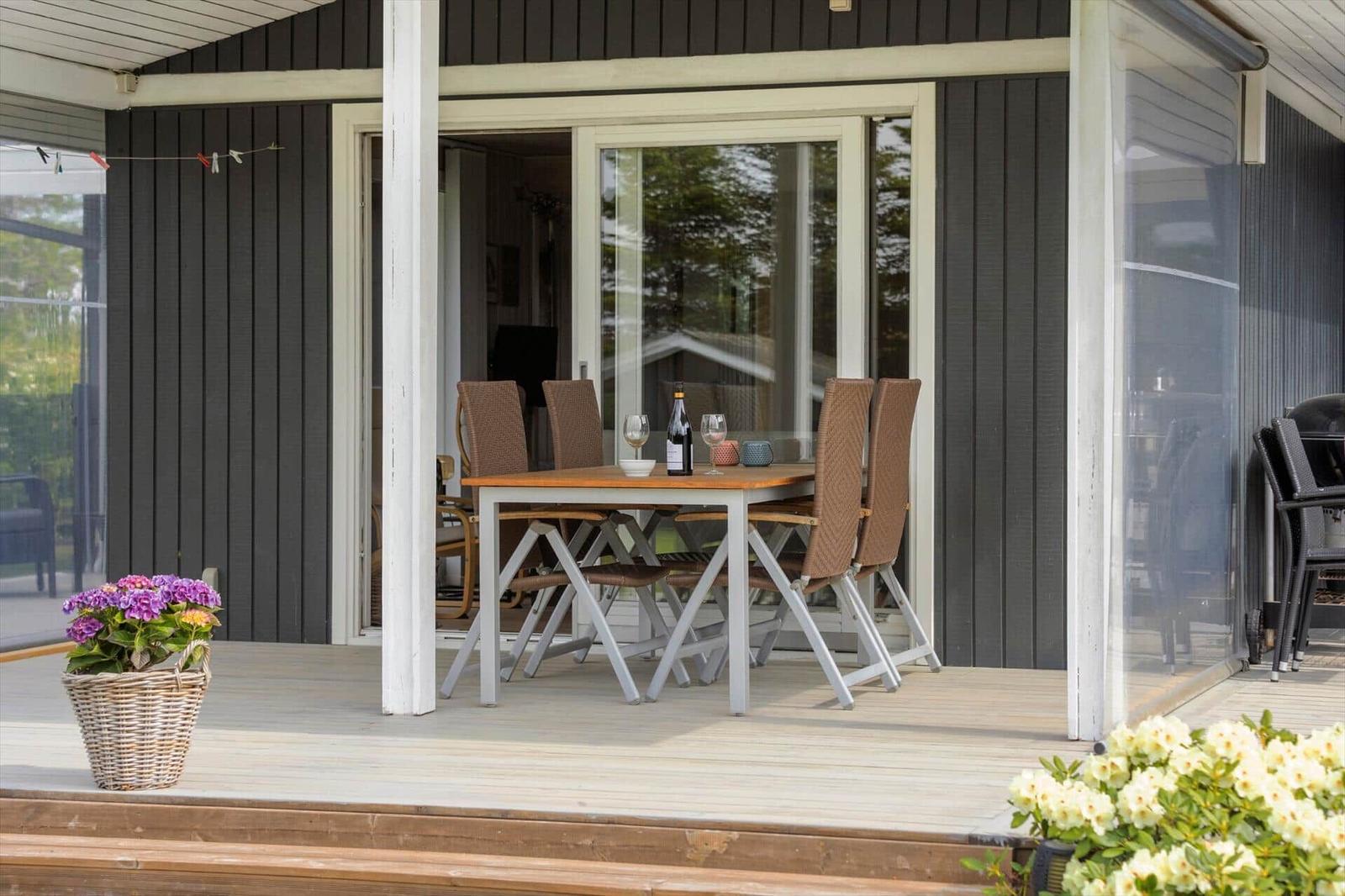 Patio with dining table, chairs, and flowers. Entrance to the house.