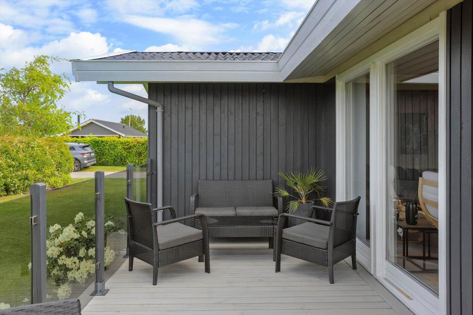 Deck with seating group, plant, and view of garden