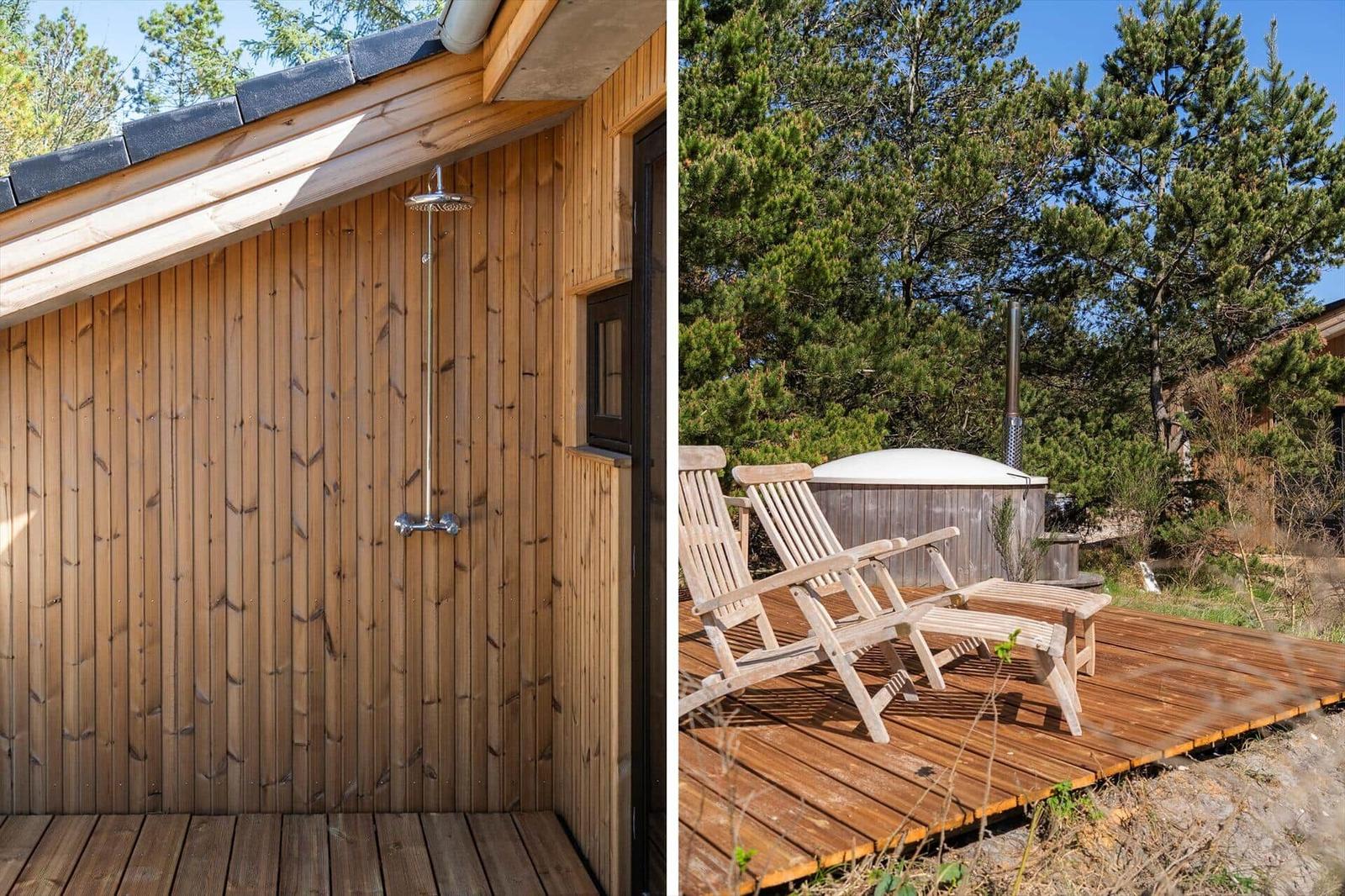 Outdoor shower next to wooden house with roof. Wooden deck with lounge chairs and hot tub.
