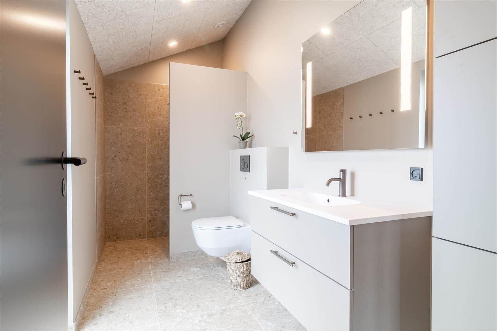 Moderne Badezimmer mit Waschbecken, Spiegel und Toilette.