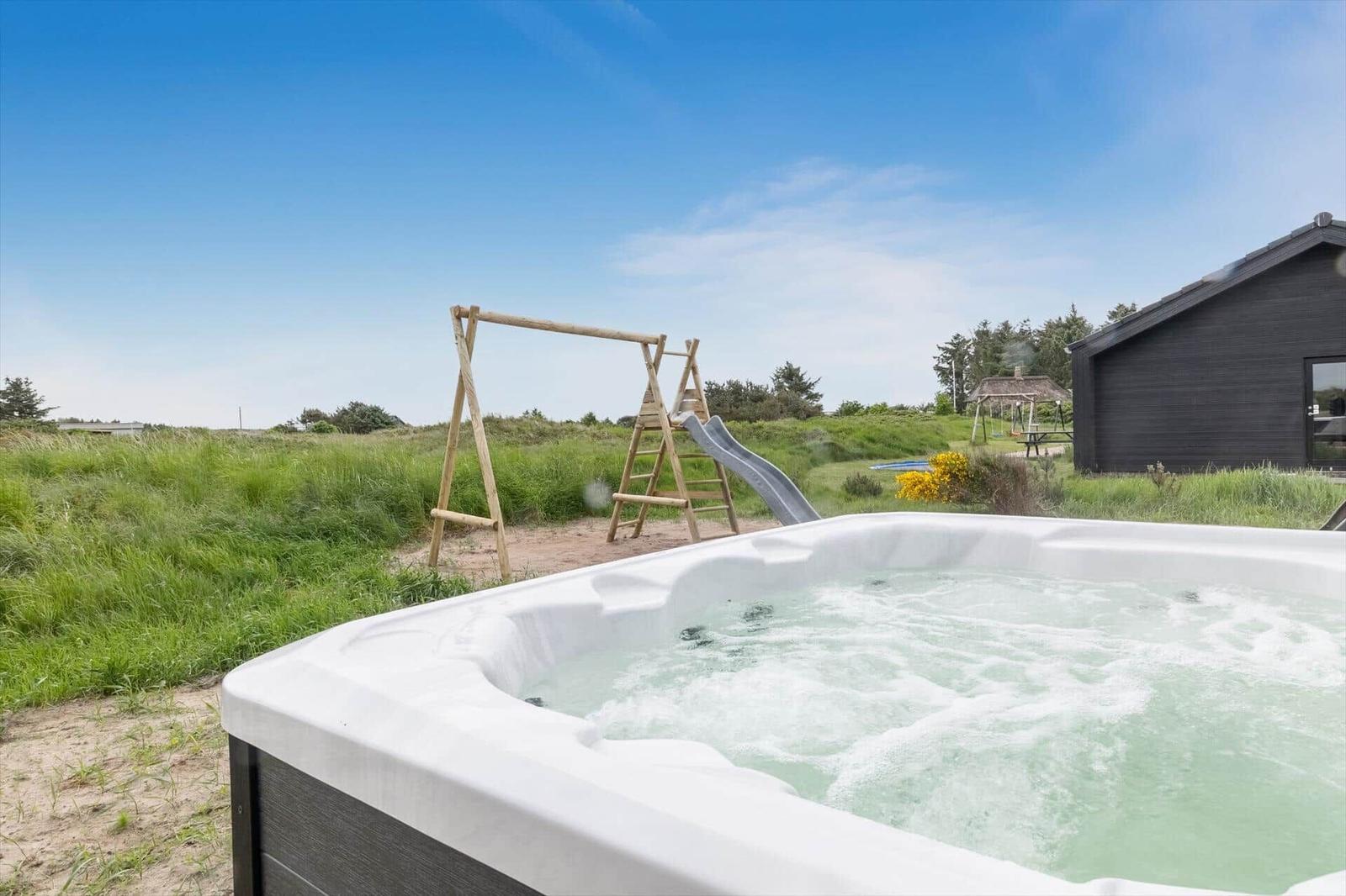 Ein Whirlpool mit Blick auf einen Spielplatz und ein Haus.