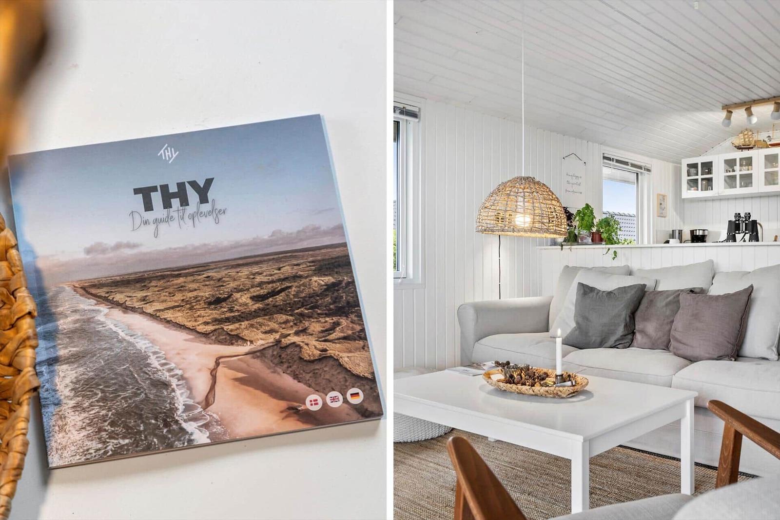 Living room with sofa, table, and ceiling. Wall picture shows coastal landscape.