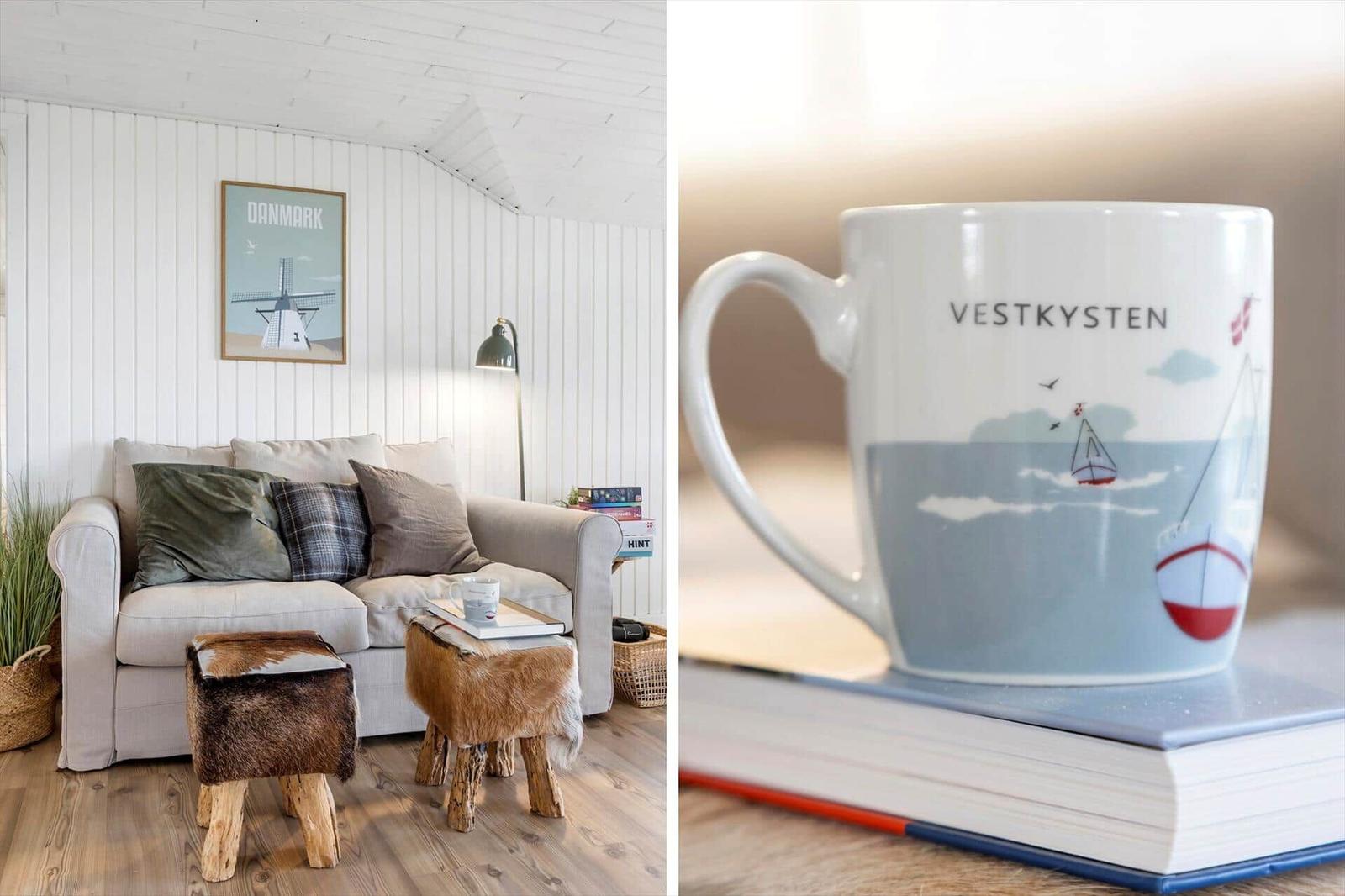 Living room with sofa, stools, and wall art. Mug with sailboat design.