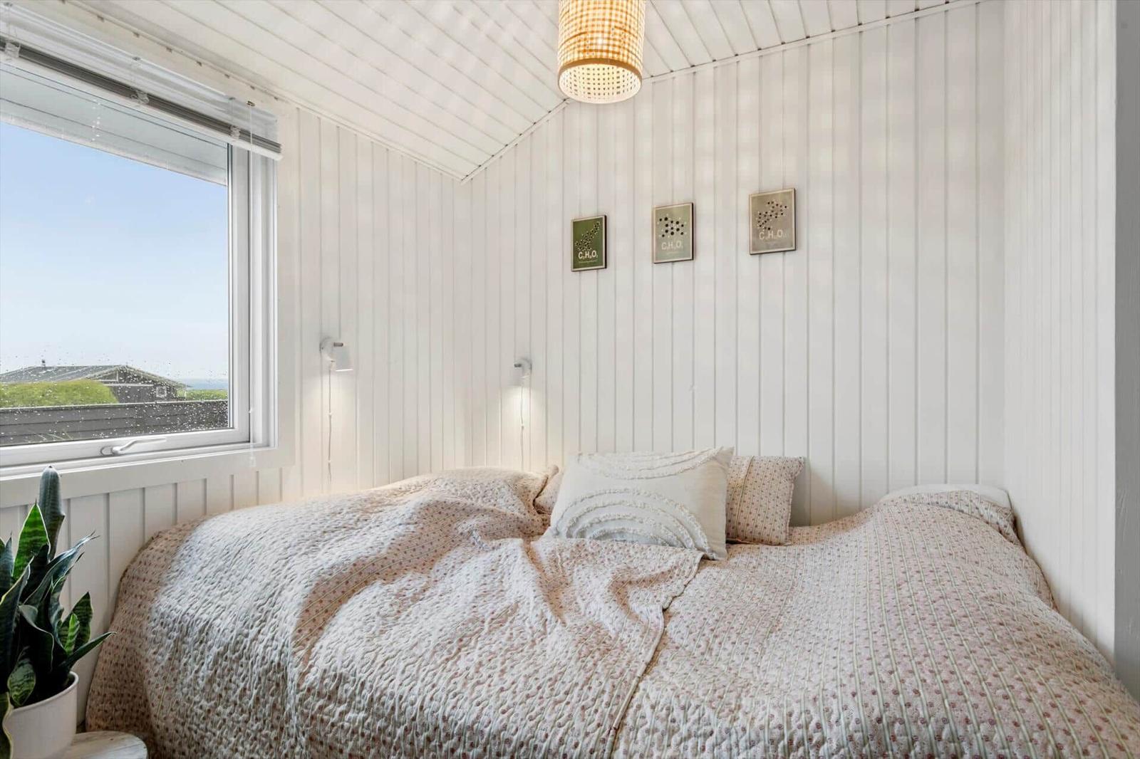 Bedroom with bed, window, and wall art