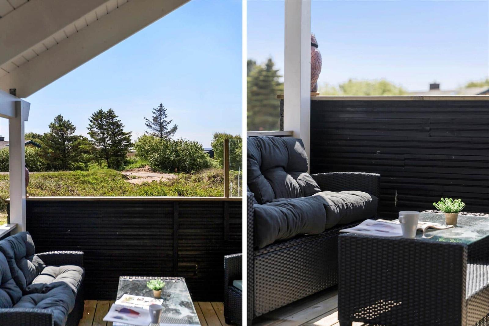 Terrasse mit Sitzgruppe und Blick auf grüne Landschaft.