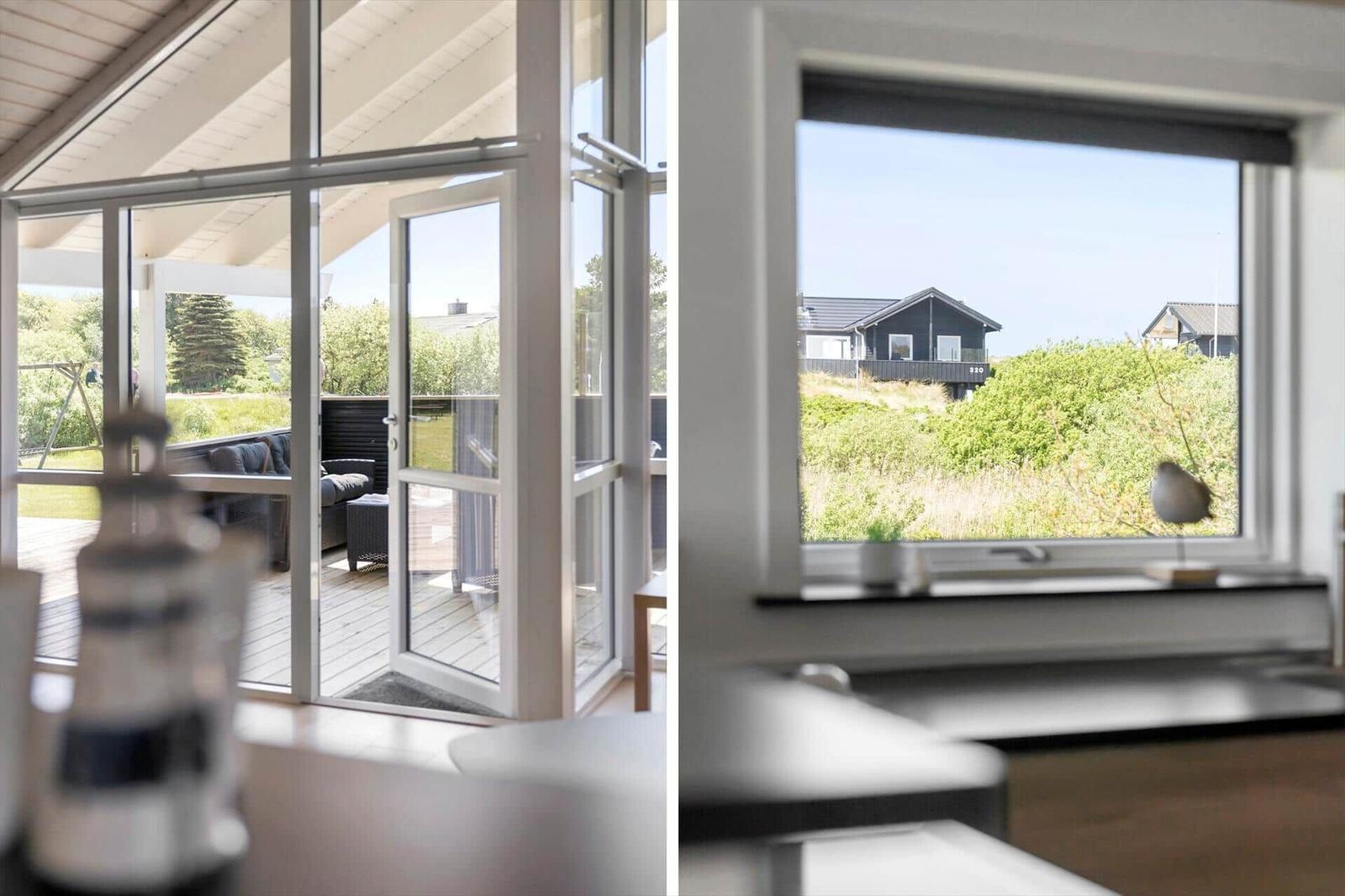 Große Fenster und Glastüren führen auf eine Terrasse mit Gartenansicht.