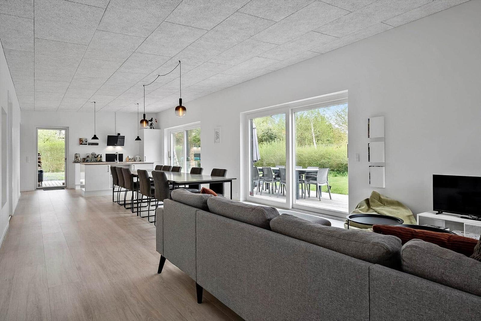 Wohn- und Essbereich mit Sofa, Esstisch und Blick auf den Garten.