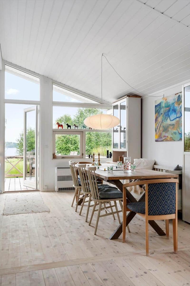 Esszimmer mit Holztisch, Stühlen und Blick auf den Garten.