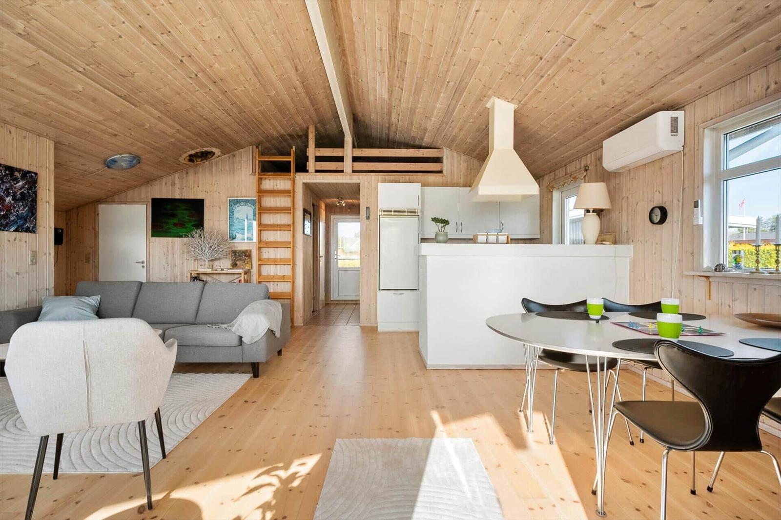 Living area with dining area, kitchen, and sleeping area on upper level.
