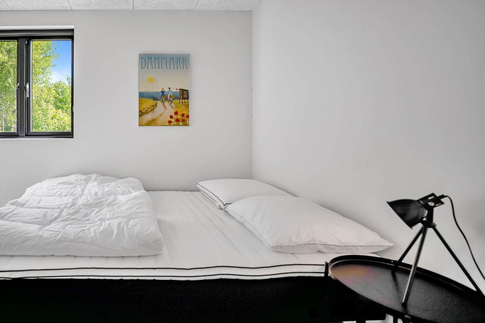 Bedroom with bed, window, and wall art with Denmark.