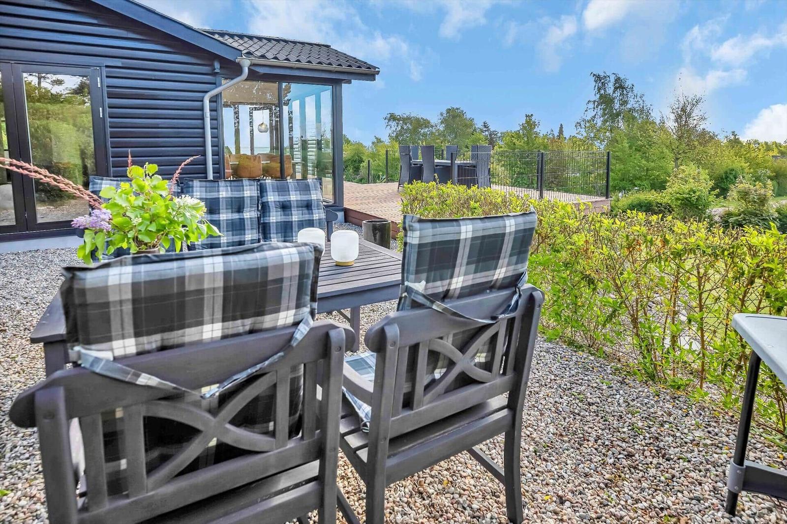 Terrace with seating area and view of garden and house.