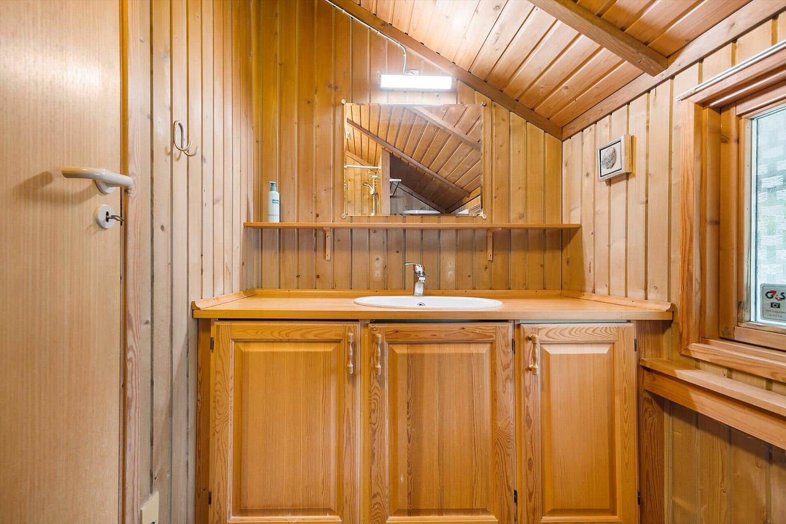Holzverkleidete Badewanne mit Spiegel und Waschbecken