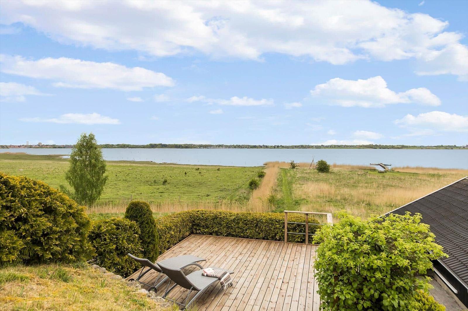Terrasse mit Liegestühlen bietet Blick auf Fluss und Grünland.