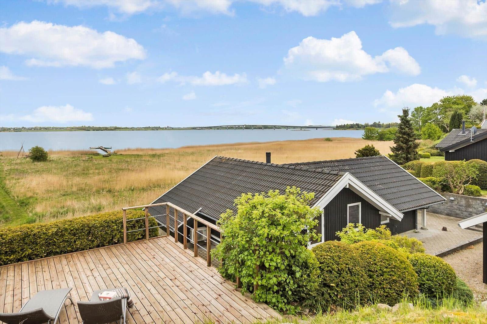 Schwarzes Haus mit Terrasse, Blick auf Wasser und Brücke