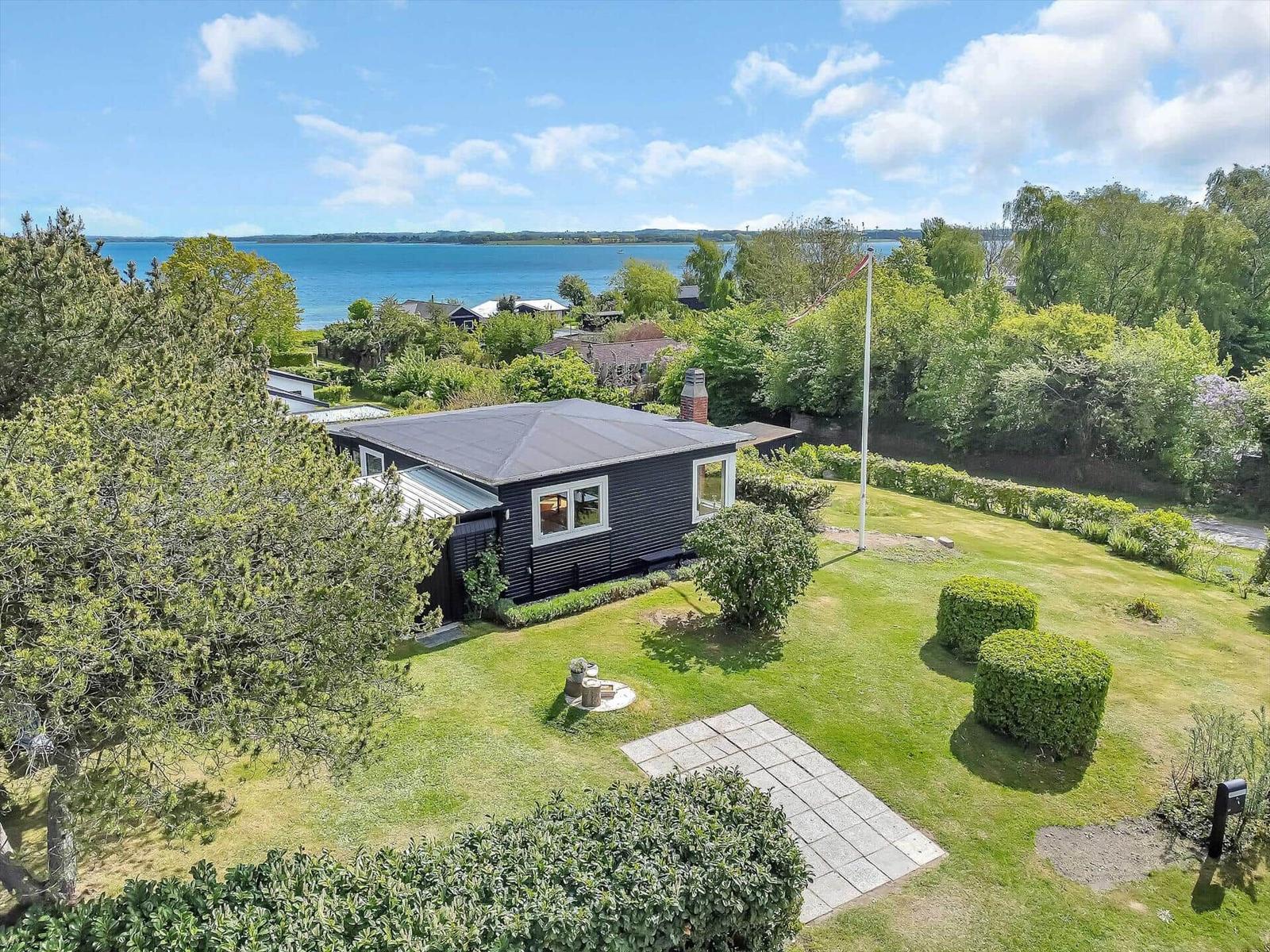 Schwarzes Haus mit Garten und Blick auf Wasser